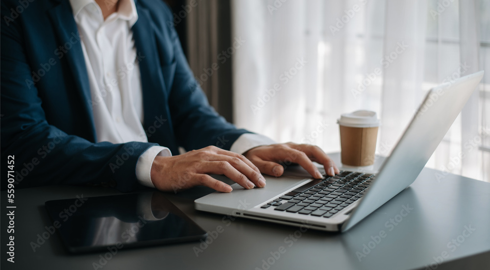 Businessman hands typing on smartphone and  laptop keyboard in morning light computer, typing, online in office - obrazy, fototapety, plakaty 