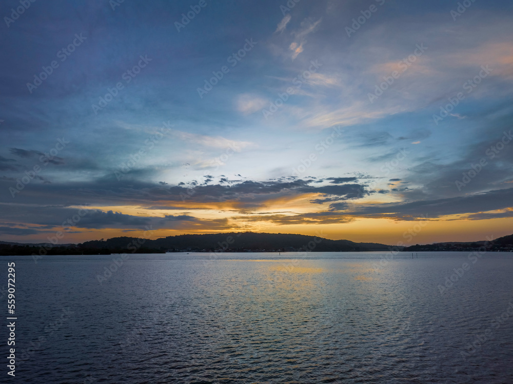 Fototapeta premium After the rain sunrise waterscape with clouds