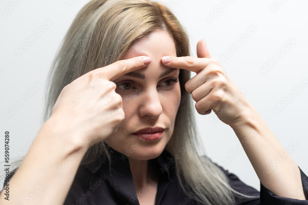 woman shows lifting effect on young female face. woman shows lifting effect on young female face.
