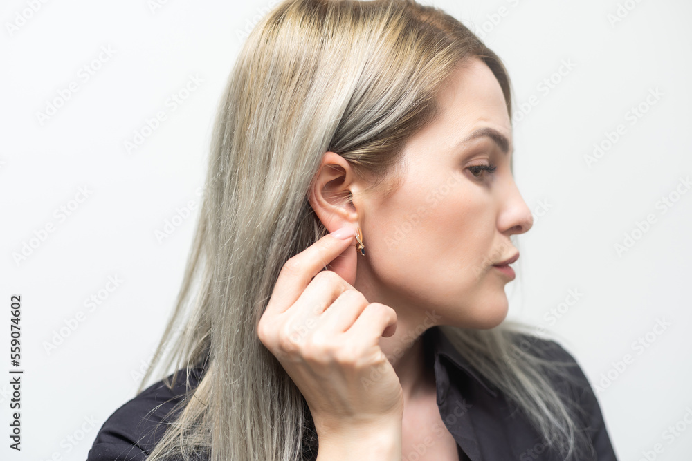 the woman shows her ear.