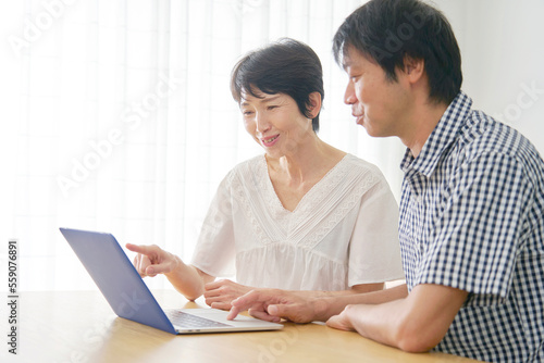 家でパソコンを使う熟年夫婦