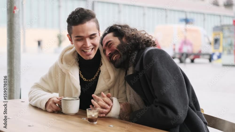Gay lovers drinking coffee in an outdoor cafeteria Gay lovers drinking coffee in an outdoor cafeteria