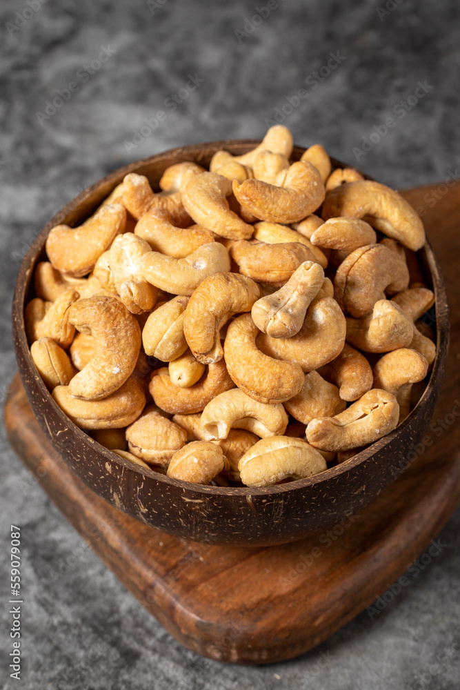Cashew nuts on dark background. Fresh cashews in coconut bowl. Studio shoot. close up Cashew nuts on dark background. Fresh cashews in coconut bowl. Studio shoot. close up