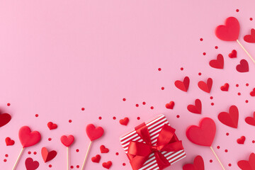 Saint Valentine day background with gift box and various red hearts. Flat lay style greeting composition.
