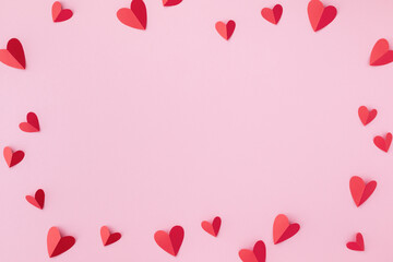 Valentine day greeting card or banner. Paper red hearts frame on pink background.