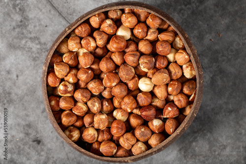 Fresh hazelnut nuts on dark background. Nuts in a coconut bowl. Studio shoot. Top view