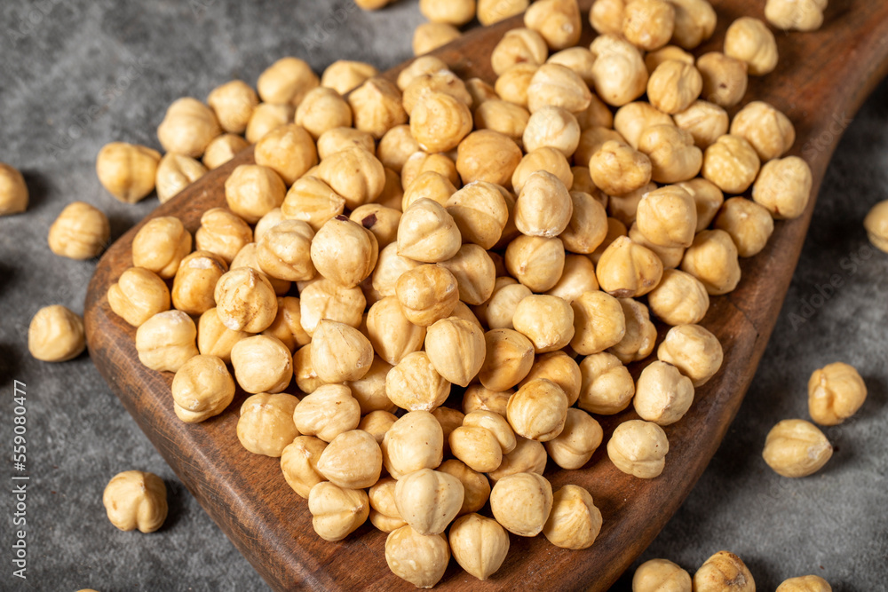 Roasted hazelnuts on a wooden serving board. A pile of nuts. Studio shoot. close up Roasted hazelnuts on a wooden serving board. A pile of nuts. Studio shoot. close up