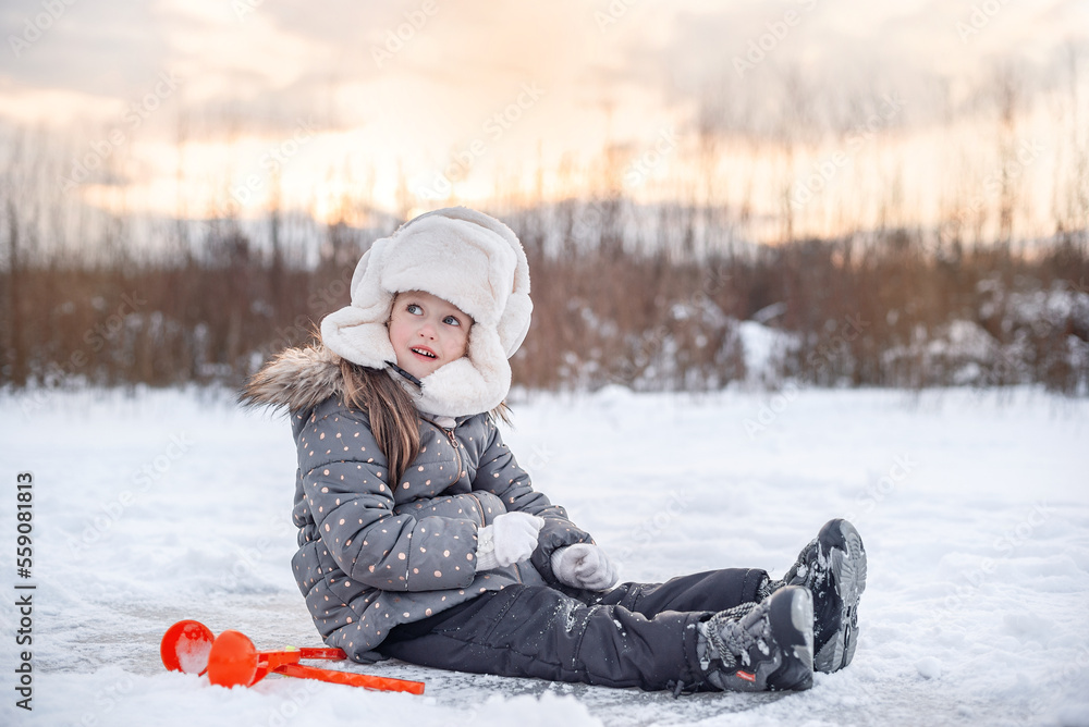 girl is sitting on the snow river at the sunset girl is sitting on the snow river at the sunset