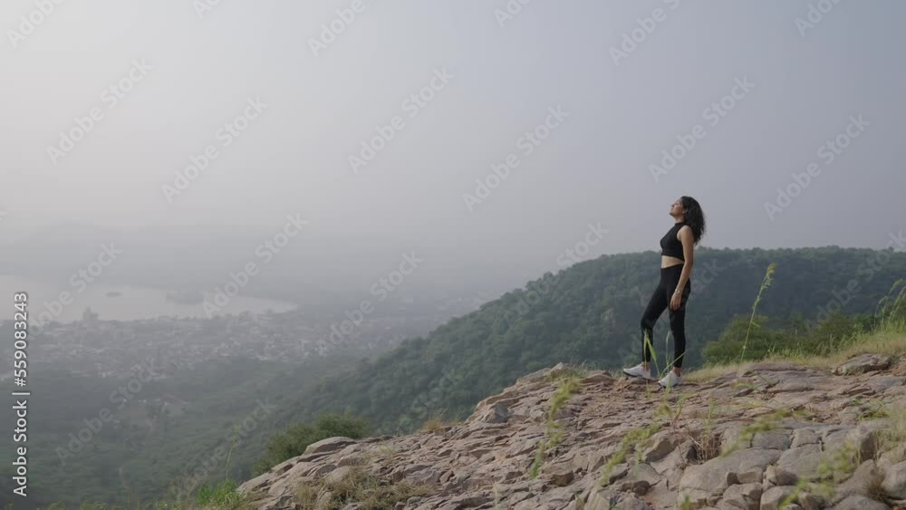 A Indian beautiful women climb and exercises at the top mountain in the morning. Asian young girl climb happy on mountain top slow motion shot and the winner with beautiful morning view sky. A Indian beautiful women climb and exercises at the top mountain in the morning. Asian young girl climb happy on mountain top slow motion shot and the winner with beautiful morning view sky.