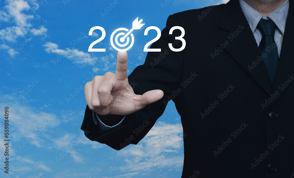Businessman pressing 2023 letter with goal icon over blue sky with white clouds, Business happy new year 2023 success concept Businessman pressing 2023 letter with goal icon over blue sky with white clouds, Business happy new year 2023 success concept