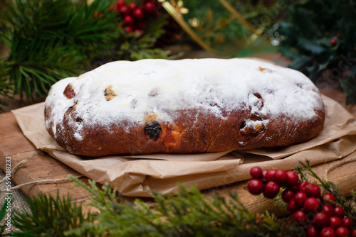 Christmas stollen its a Traditional Dresdner German Christmas cake Stollen with raising, berries and nuts. Christmas decorations photo