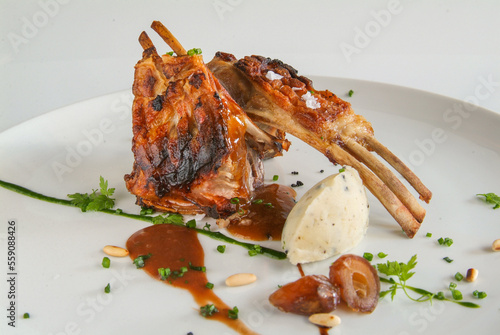 Cordero asado con puré de olivas negras, caramelo de módena, dátiles y piñones