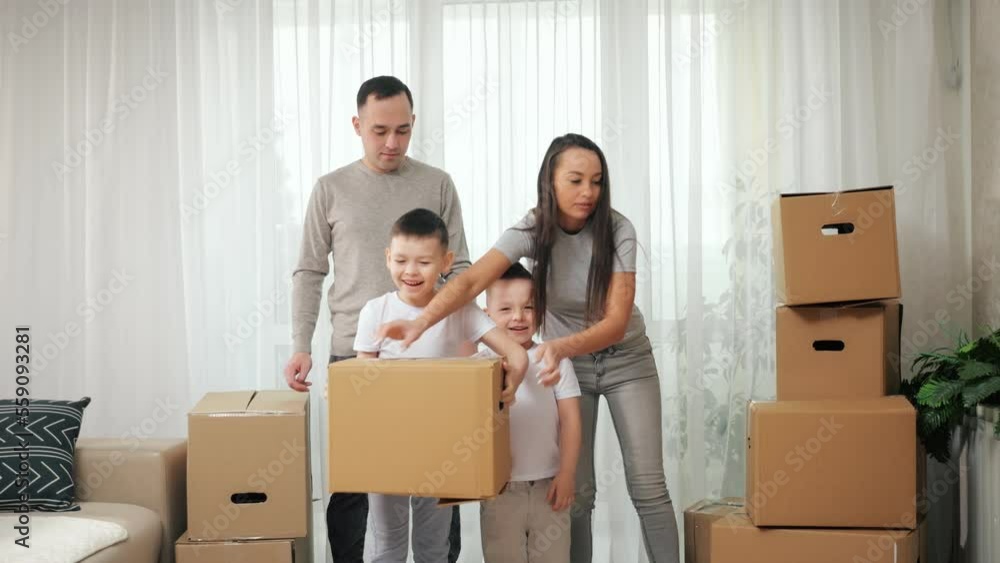 Children want to help parents carry boxes in new apartment. Boy kids enjoy helping parents with moving into new house and carrying packages Children want to help parents carry boxes in new apartment. Boy kids enjoy helping parents with moving into new house and carrying packages