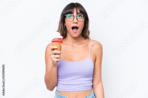 Young caucasian woman with a cornet ice cream over isolated white background looking up and with surprised expression