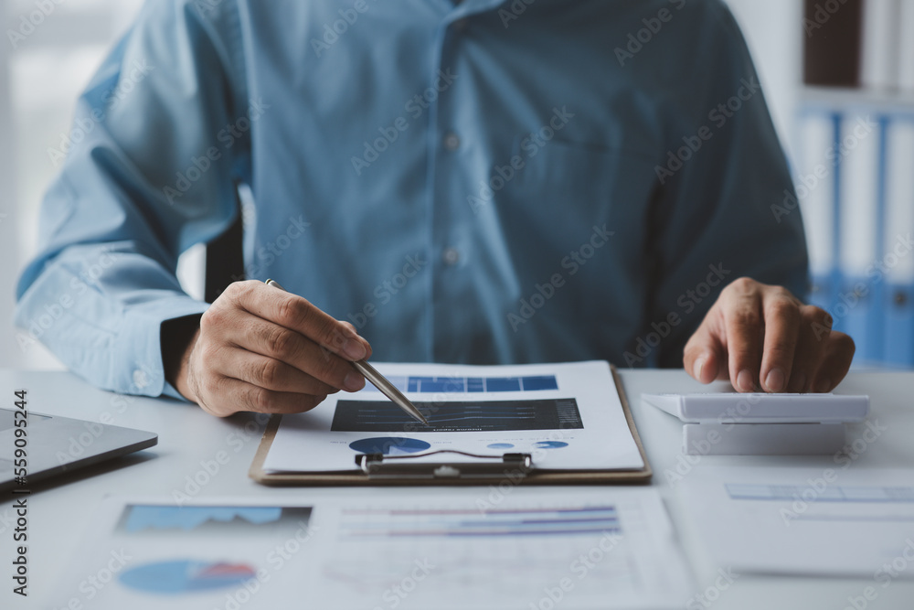 A business finance man is reviewing a company's financial documents prepared by the Finance Department for a meeting with business partners. Concept of validating the accuracy of financial numbers. A business finance man is reviewing a company's financial documents prepared by the Finance Department for a meeting with business partners. Concept of validating the accuracy of financial numbers.