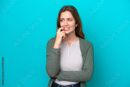 Young caucasian woman isolated on blue background nervous and scared