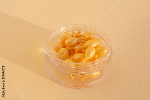 capsules with a cream or serum for face treatment on beige background. Single dose capsules for beauty care. collagen peptides or hyaluronic acid. Skin care background in minimal style.