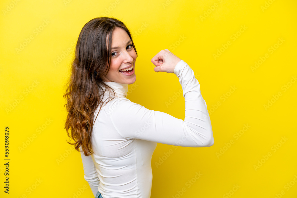 Young caucasian woman isolated on yellow background doing strong gesture Young caucasian woman isolated on yellow background doing strong gesture