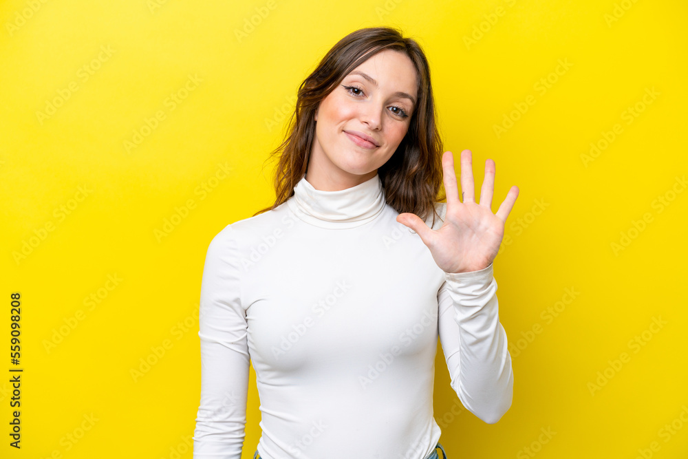 Young caucasian woman isolated on yellow background counting five with fingers Young caucasian woman isolated on yellow background counting five with fingers