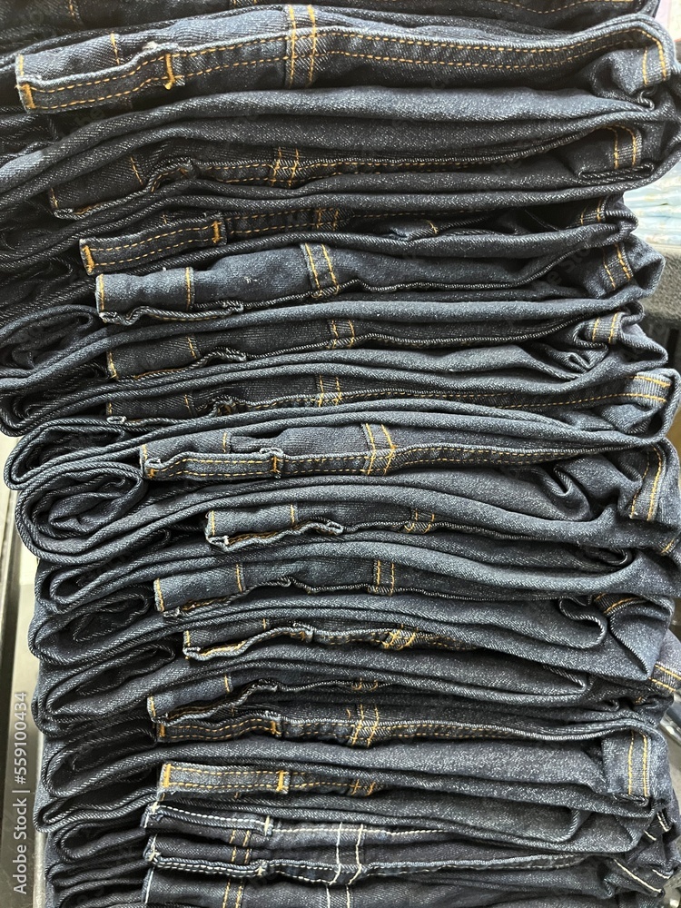 Pile of blue jeans ready for display and sale. jeans neatly arranged in the distro cupboard. Strong texture and seams on the pants. Neat trouser fold. mockup of a pile of pants for the design template Pile of blue jeans ready for display and sale. jeans neatly arranged in the distro cupboard. Strong texture and seams on the pants. Neat trouser fold. mockup of a pile of pants for the design template