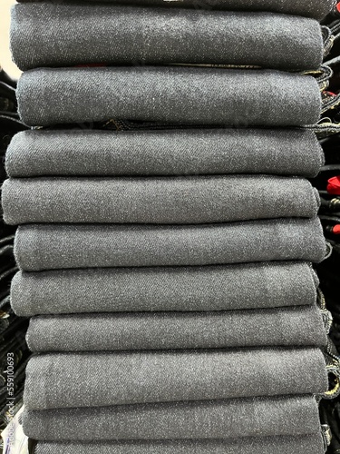 Pile of blue jeans ready for display and sale. jeans neatly arranged in the distro cupboard. Strong texture and seams on the pants. Neat trouser fold. mockup of a pile of pants for the design template