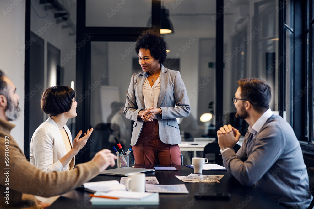 © Dusan Petkovic - A multiracial female team leader is having business meeting with employees in the office.
