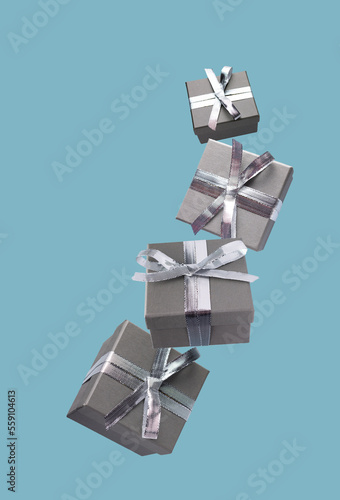 gift gray boxes tied with silver silk ribbons fly on a blue background