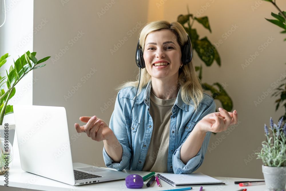 Photo of charming positive person sit behind desktop look use laptop have good mood working home indoors Photo of charming positive person sit behind desktop look use laptop have good mood working home indoors