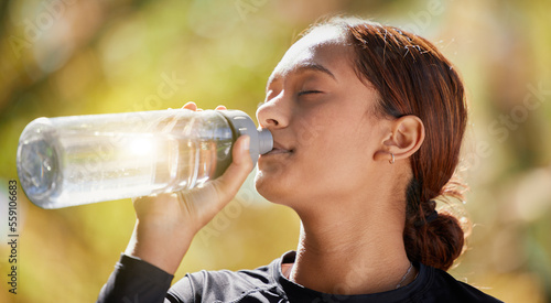 Fitness, nature and woman drinking water after running for hydration, refresh and thirst. Sports, runner and female athlete enjoying a drink after cardio training for a race, marathon or competition.