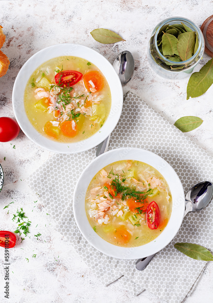Fish soup with salmon, vegetables and rice in white bowl. Top view, above Fish soup with salmon, vegetables and rice in white bowl. Top view, above