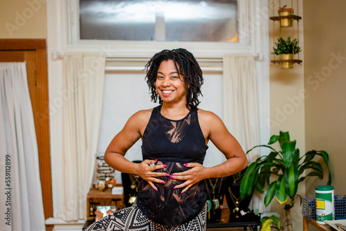 a yoga instructor smiles and demonstrates deep breathing photo