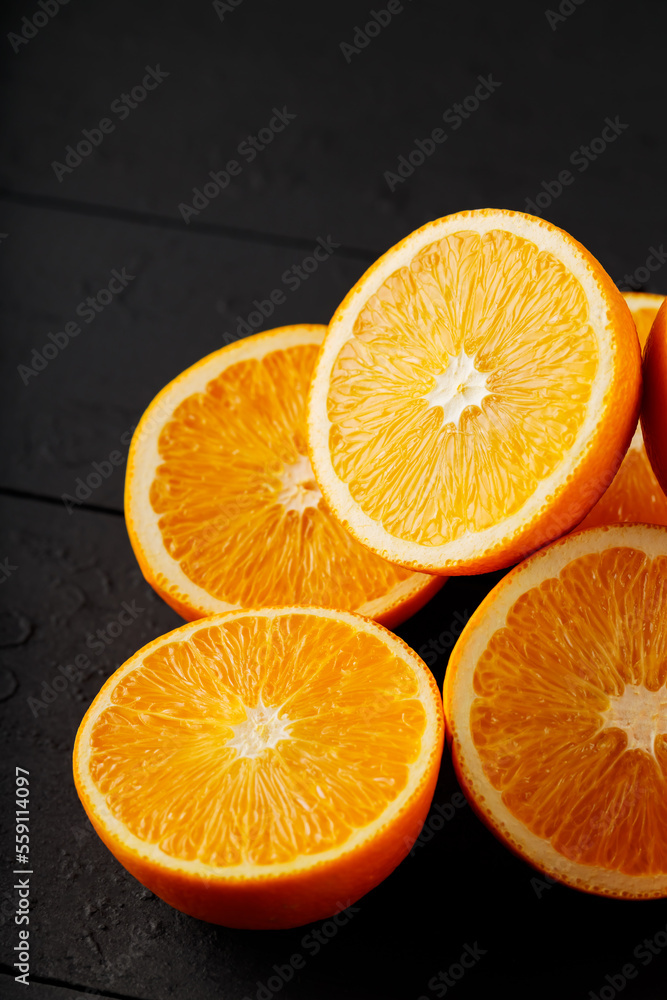 Fototapeta premium Fresh ripe oranges on a dark wooden table. Fresh citrus fruits for vegetarian dishes