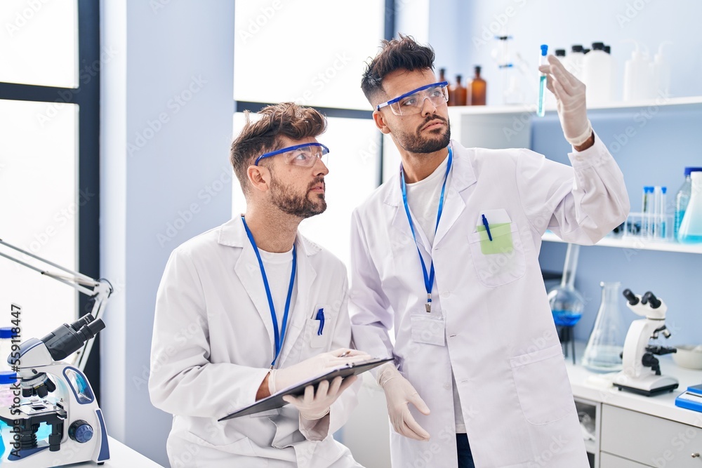 Young couple wearing scientist uniform working at laboratory Young couple wearing scientist uniform working at laboratory