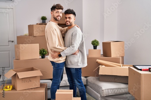 Young couple hugging each other standing at new home