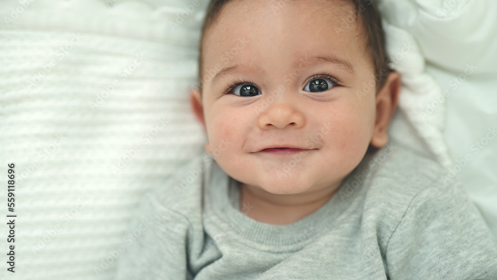 Adorable hispanic baby smiling confident lying on bed at bedroom Adorable hispanic baby smiling confident lying on bed at bedroom