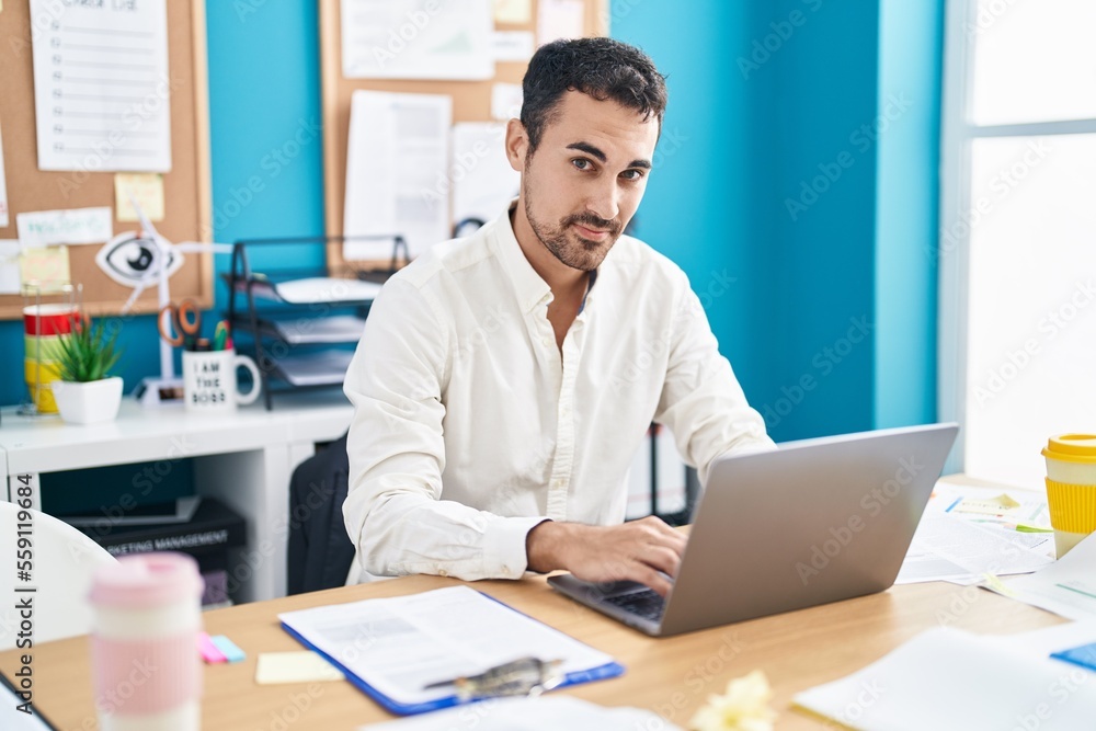 Young hispanic man business worker using laptop working at office