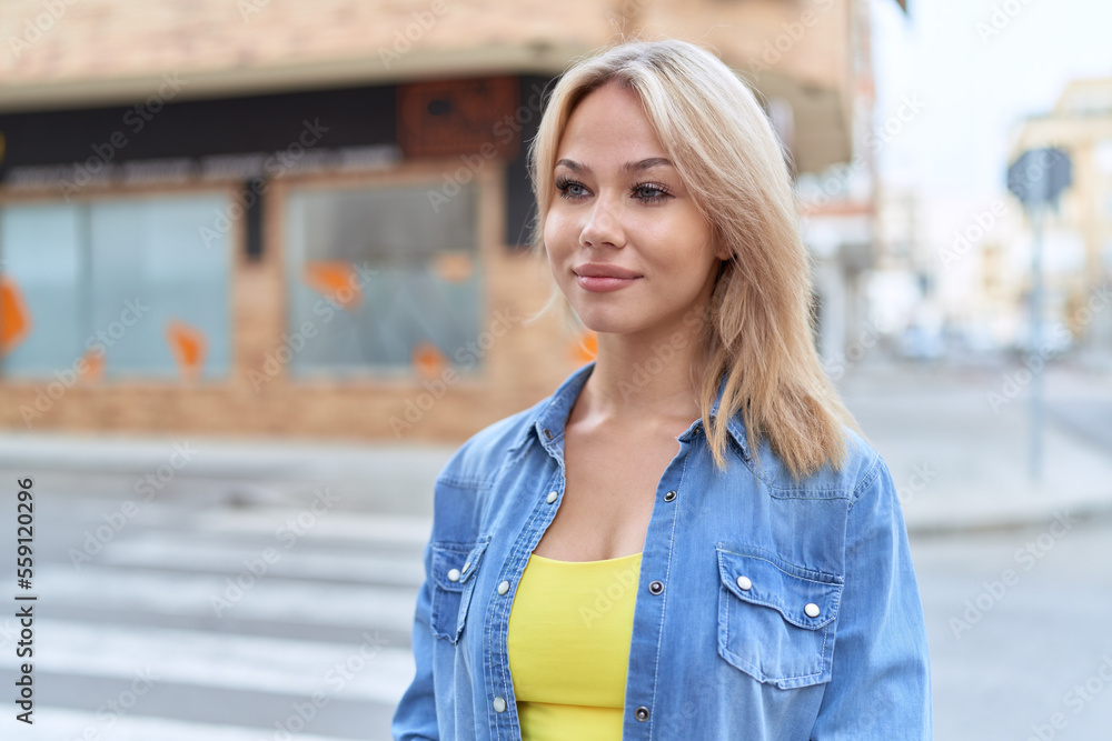 Young blonde woman smiling confident looking to the side at street Young blonde woman smiling confident looking to the side at street