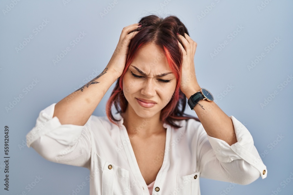 Young caucasian woman wearing casual white shirt over isolated background suffering from headache desperate and stressed because pain and migraine. hands on head. Young caucasian woman wearing casual white shirt over isolated background suffering from headache desperate and stressed because pain and migraine. hands on head.