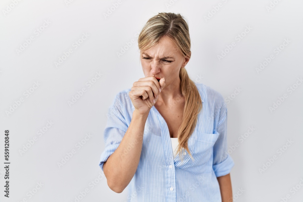 Beautiful blonde woman standing over white background feeling unwell and coughing as symptom for cold or bronchitis. health care concept. Beautiful blonde woman standing over white background feeling unwell and coughing as symptom for cold or bronchitis. health care concept.