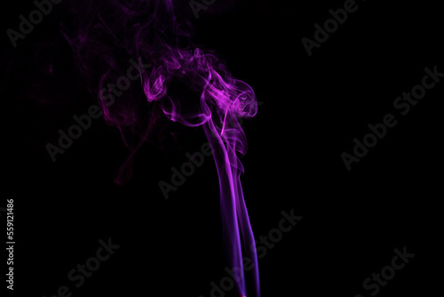 incense stick with purple smoke against black background
