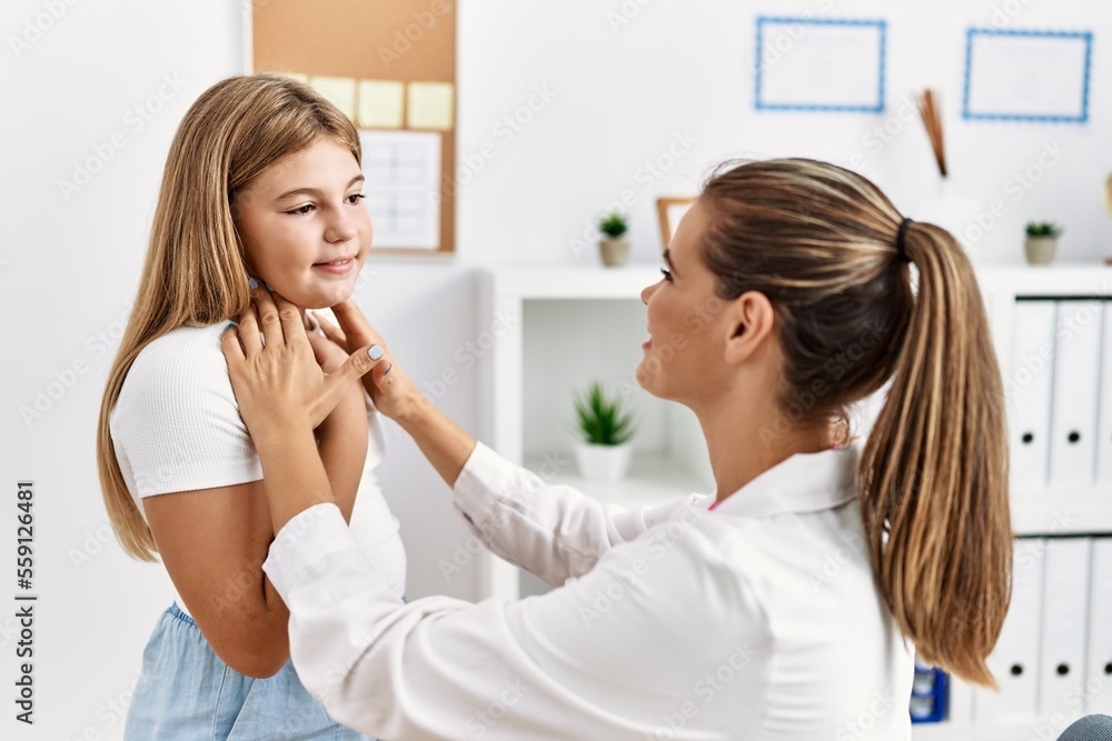 Woman and girl pediatrician and patient auscultating throat having medical consultation at clinic Woman and girl pediatrician and patient auscultating throat having medical consultation at clinic