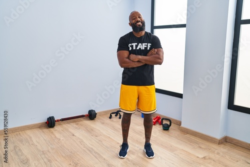African american man working at fitness gym happy face smiling with crossed arms looking at the camera. positive person.