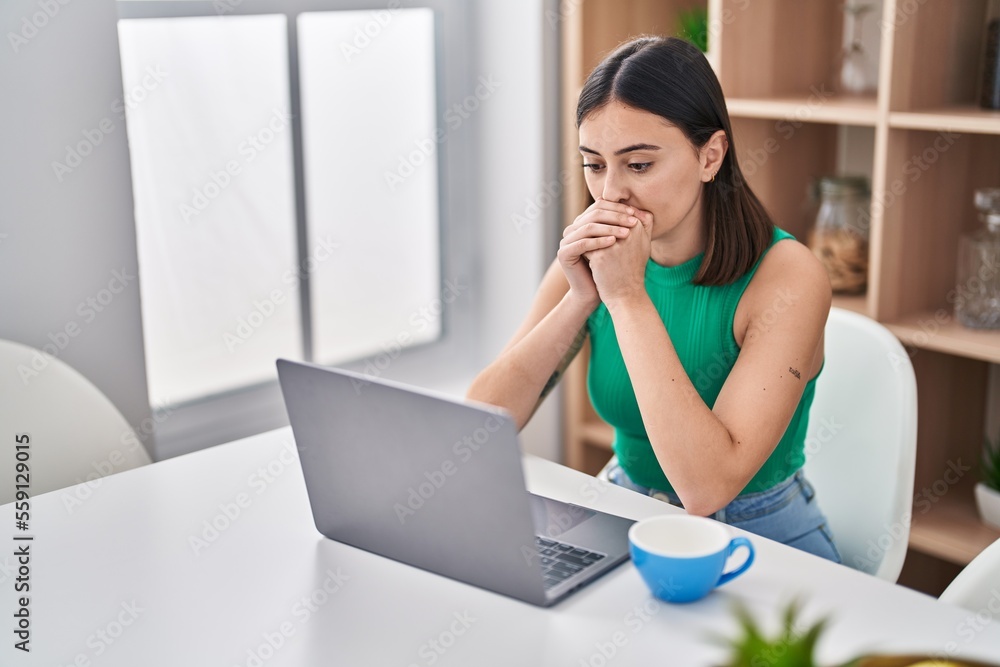 Young hispanic woman using laptop with worried expression at home Young hispanic woman using laptop with worried expression at home