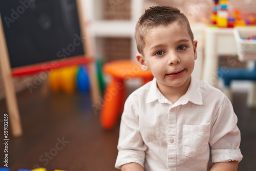 Adorable toddler smiling confident sitting on floor at kindergarten