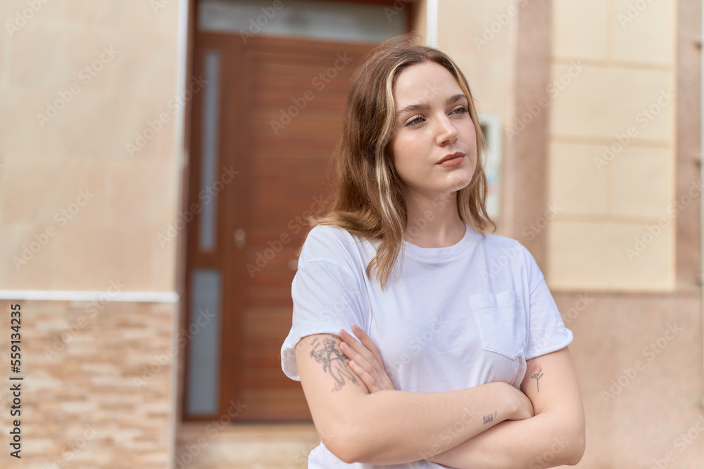 Young caucasian woman standing with arms crossed gesture and serious expression at street Young caucasian woman standing with arms crossed gesture and serious expression at street