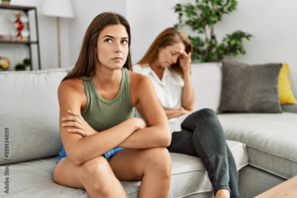Mother and daughter unhappy arguing sitting on sofa at home Mother and daughter unhappy arguing sitting on sofa at home
