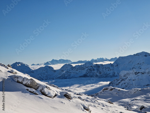 Bergpanorama mit Schnee auf den Gipfeln und Wolken im Tal