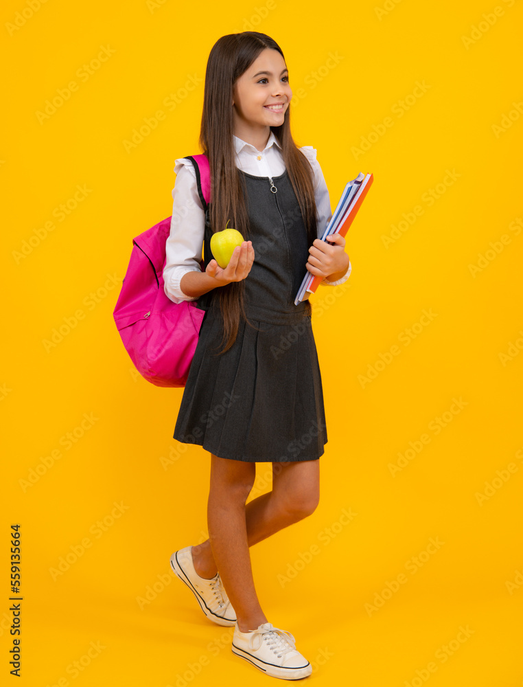 Schoolchild, teenage student girl with school bag backpack hold aplle and books on yellow isolated studio background. Children school and education concept. Schoolchild, teenage student girl with school bag backpack hold aplle and books on yellow isolated studio background. Children school and education concept.