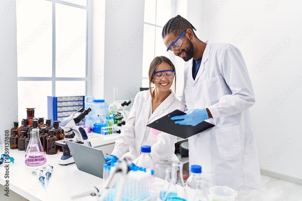 Man and woman scientist partners smiling confident working at laboratory Man and woman scientist partners smiling confident working at laboratory