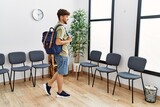 Young arab man wearing backpack standing at waiting room
